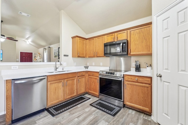 5530 Exeter Dr, Prosper, TX 75078 - kitchen featuring appliances with stainless steel finishes, lofted ceiling, a sink, light wood finished floors, and light countertops