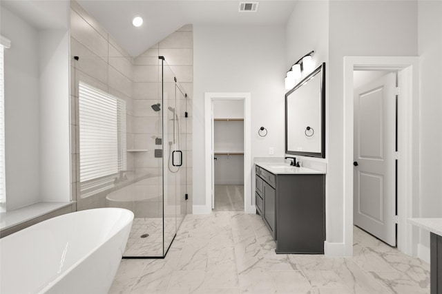 329 Lovett Ln, Burleson, TX 76028 - bathroom with vanity, a freestanding bath, a shower stall, marble finish flooring, and a walk in closet