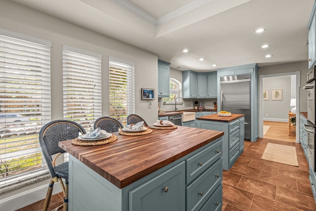 3304 Bowden Hill Ln N, Colleyville, TX 76034 - kitchen with butcher block counters, stainless steel appliances, recessed lighting, a center island, and ornamental molding
