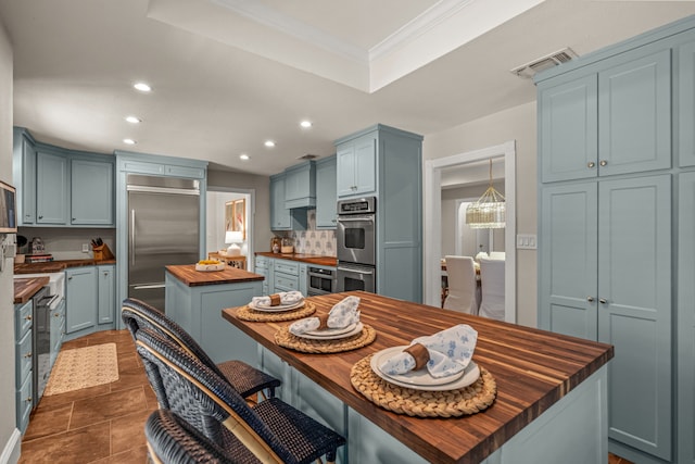 3304 Bowden Hill Ln N, Colleyville, TX 76034 - kitchen featuring wooden counters, appliances with stainless steel finishes, recessed lighting, a kitchen island, and a raised ceiling