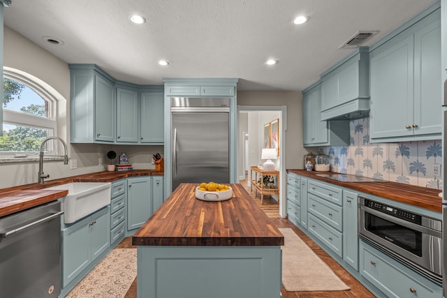 3304 Bowden Hill Ln N, Colleyville, TX 76034 - kitchen featuring butcher block counters, appliances with stainless steel finishes, a sink, recessed lighting, and a textured ceiling