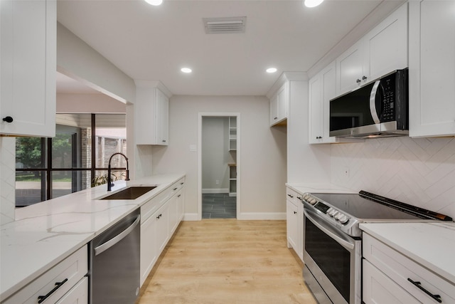 3 Collins Ct, Richardson, TX 75081 - kitchen with stainless steel appliances, decorative backsplash, white cabinets, recessed lighting, and light wood-style floors
