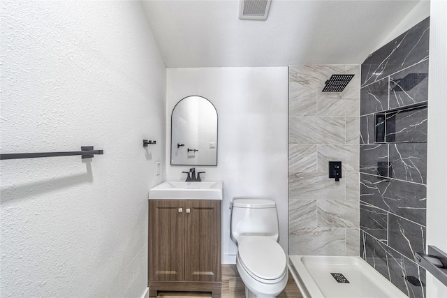 10816 Joaquin Dr, Dallas, TX 75228 - bathroom featuring vanity, tiled shower, toilet, and baseboards