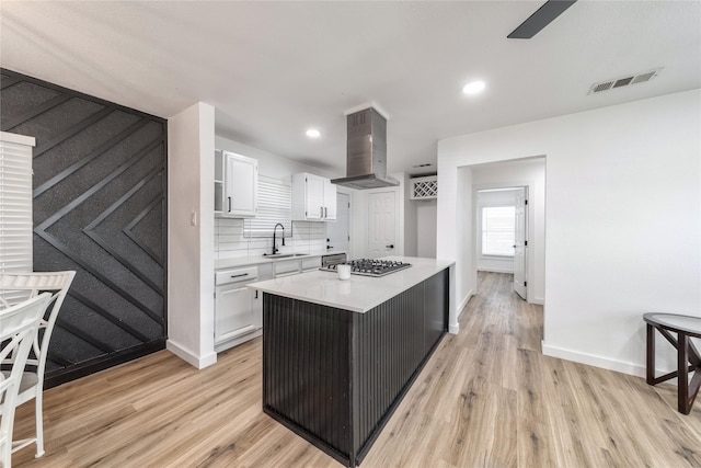 10816 Joaquin Dr, Dallas, TX 75228 - kitchen featuring a sink, island range hood, white cabinetry, light wood-style flooring, and recessed lighting