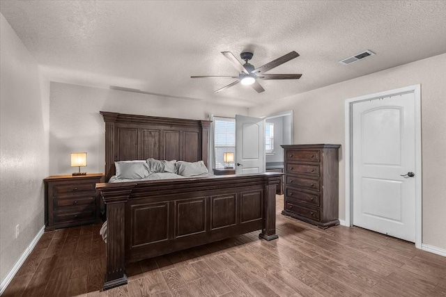 2250 Poolville Cut Off Rd, Poolville, TX 76487 - bedroom with dark wood-style floors, a textured ceiling, baseboards, and ceiling fan