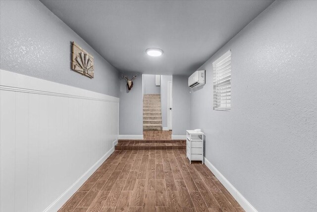 2250 Poolville Cut Off Rd, Poolville, TX 76487 - hall featuring a wall mounted AC, wood finished floors, stairs, and baseboards
