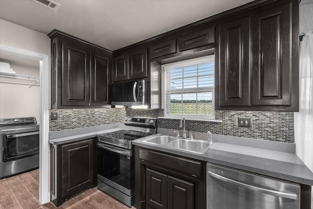 2250 Poolville Cut Off Rd, Poolville, TX 76487 - kitchen with stainless steel appliances, a sink, washer / dryer, dark cabinets, and a textured ceiling