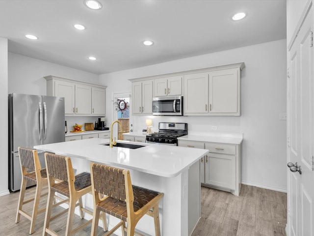 1705 Wayne Ln, Celina, TX 75009 - kitchen with stainless steel appliances, an island with sink, light countertops, light wood-style flooring, and recessed lighting