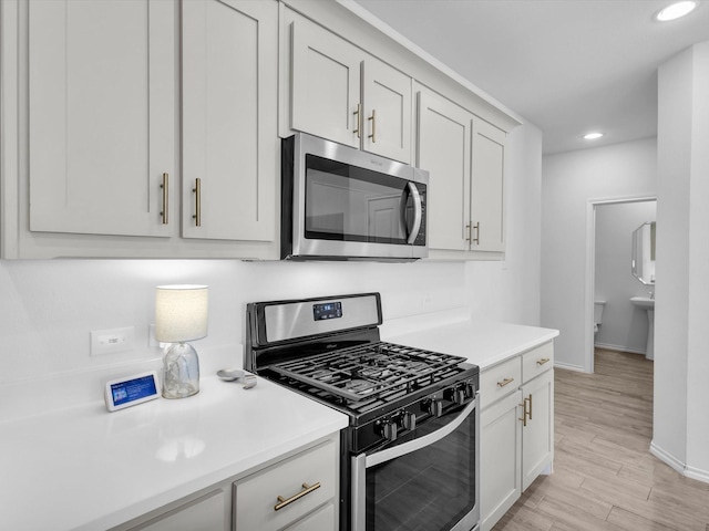 1705 Wayne Ln, Celina, TX 75009 - kitchen with appliances with stainless steel finishes, light countertops, light wood finished floors, recessed lighting, and white cabinetry