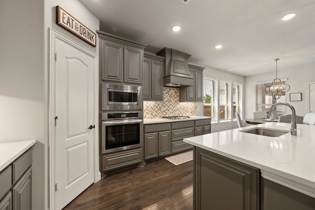 923 Timber Ridge Dr, Justin, TX 76247 - kitchen with stainless steel appliances, a sink, gray cabinets, custom range hood, and backsplash