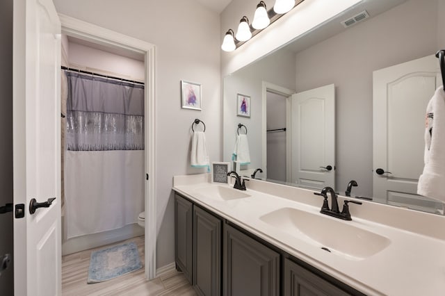 923 Timber Ridge Dr, Justin, TX 76247 - bathroom featuring double vanity, toilet, wood finished floors, and baseboards