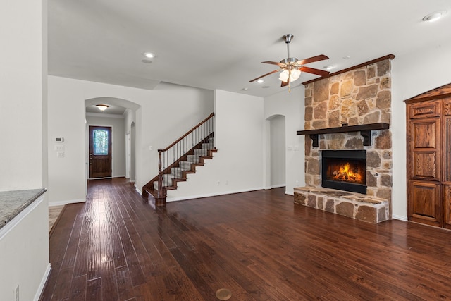 1205 Wynne Dr, Garland, TX 75044 - unfurnished living room with arched walkways, ceiling fan, a fireplace, hardwood / wood-style flooring, and stairway