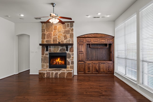 1205 Wynne Dr, Garland, TX 75044 - unfurnished living room featuring a ceiling fan, arched walkways, a stone fireplace, dark wood-style flooring, and recessed lighting