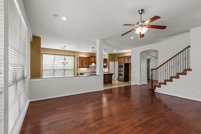 1205 Wynne Dr, Garland, TX 75044 - unfurnished living room featuring ceiling fan, arched walkways, wood finished floors, recessed lighting, and a chandelier