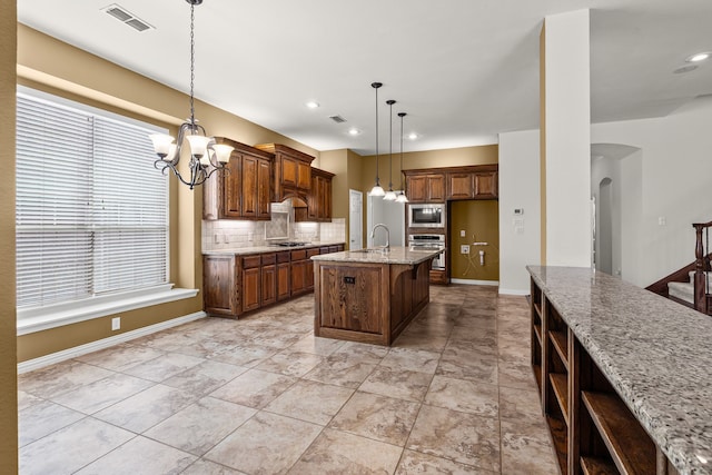 1205 Wynne Dr, Garland, TX 75044 - kitchen with stainless steel appliances, a chandelier, decorative backsplash, light stone countertops, and decorative light fixtures