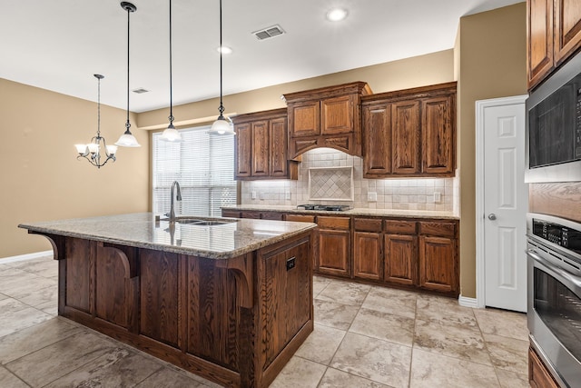 1205 Wynne Dr, Garland, TX 75044 - kitchen with a sink, stainless steel appliances, a breakfast bar, decorative backsplash, and a chandelier