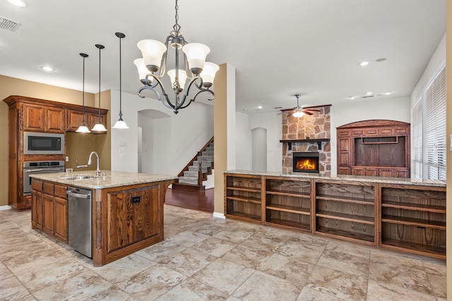 1205 Wynne Dr, Garland, TX 75044 - kitchen featuring stainless steel appliances, a sink, ceiling fan, arched walkways, and a fireplace