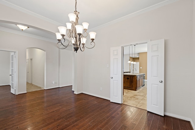 1205 Wynne Dr, Garland, TX 75044 - unfurnished room featuring arched walkways, a chandelier, a sink, dark wood-type flooring, and ornamental molding