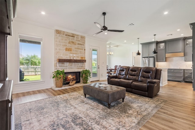 10136 Braided Briar Ln, Waco, TX 76712 - living room featuring ornamental molding, light wood finished floors, a stone fireplace, ceiling fan, and recessed lighting