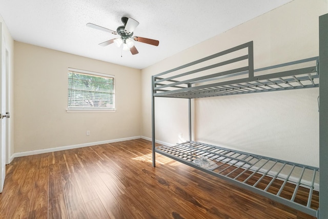 908 Cherry Laurel Ln, Arlington, TX 76012 - unfurnished bedroom featuring wood finished floors, baseboards, and a ceiling fan