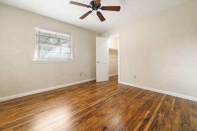 908 Cherry Laurel Ln, Arlington, TX 76012 - unfurnished bedroom featuring wood finished floors, baseboards, and a walk in closet