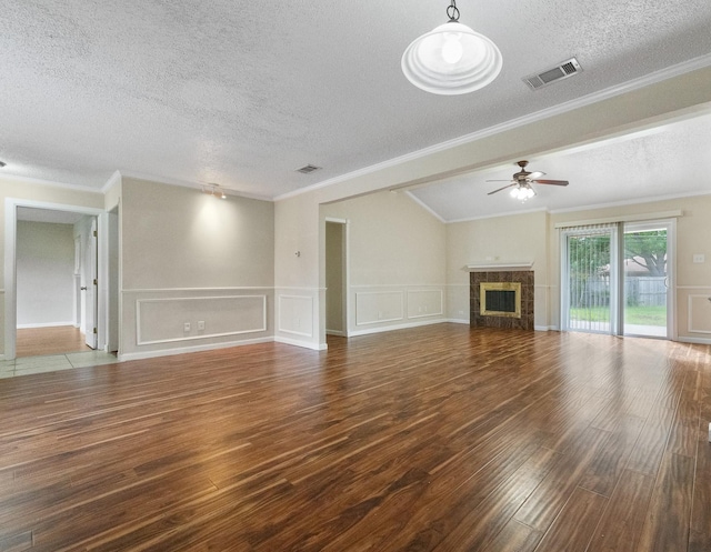 908 Cherry Laurel Ln, Arlington, TX 76012 - unfurnished living room with a textured ceiling, wood finished floors, a ceiling fan, a decorative wall, and ornamental molding