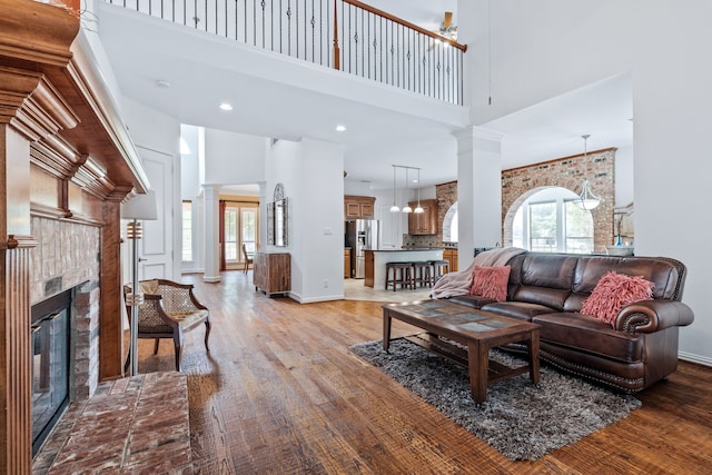 420 Bee Caves Rd, Lucas, TX 75002 - living area with a towering ceiling, ornate columns, a fireplace, light wood finished floors, and baseboards