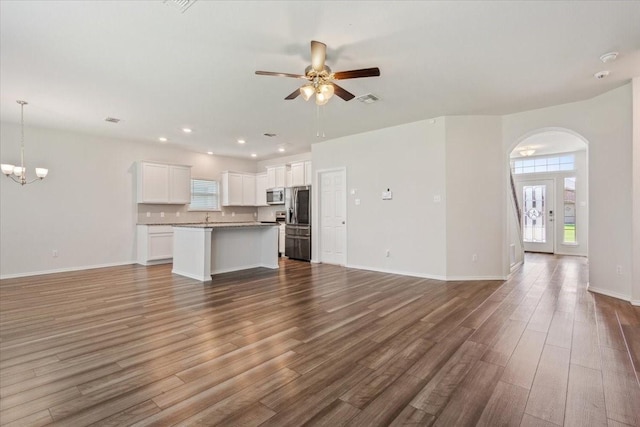 3220 Marston Rd, Lorena, TX 76655 - unfurnished living room featuring plenty of natural light, a ceiling fan, dark wood finished floors, arched walkways, and recessed lighting
