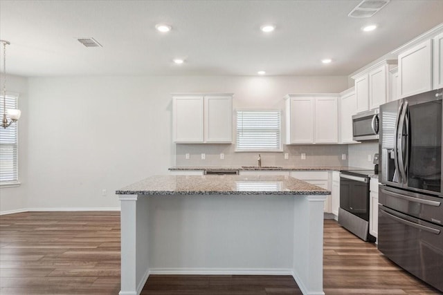 3220 Marston Rd, Lorena, TX 76655 - kitchen featuring appliances with stainless steel finishes, a sink, a kitchen island, dark wood-type flooring, and tasteful backsplash