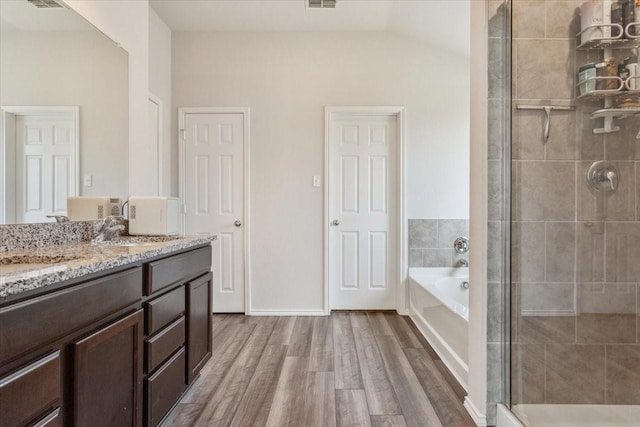 3220 Marston Rd, Lorena, TX 76655 - full bathroom featuring wood finished floors, a shower stall, a bath, vanity, and vaulted ceiling