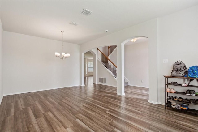 3220 Marston Rd, Lorena, TX 76655 - unfurnished room with wood finished floors, a chandelier, arched walkways, stairs, and baseboards