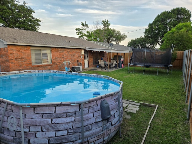 view of swimming pool with a trampoline, a patio area, and cooling unit