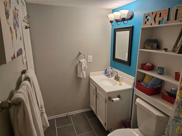 bathroom featuring tile patterned flooring, toilet, vanity, and baseboards