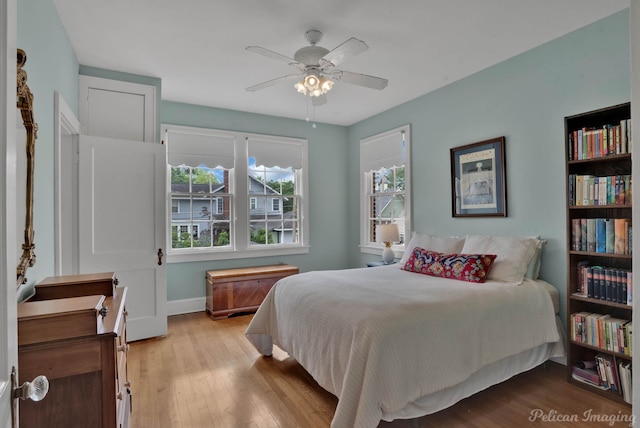 bedroom with wood finished floors, baseboards, and a ceiling fan