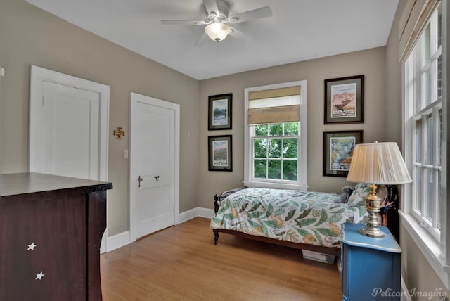 bedroom with light wood-style flooring, baseboards, and ceiling fan