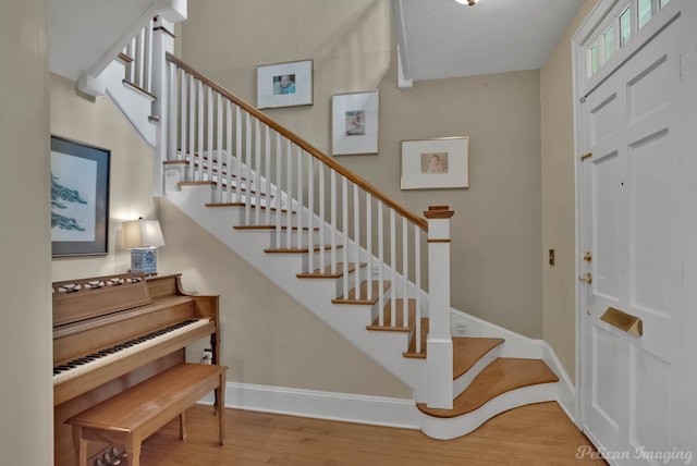 entrance foyer featuring wood finished floors, stairway, and baseboards