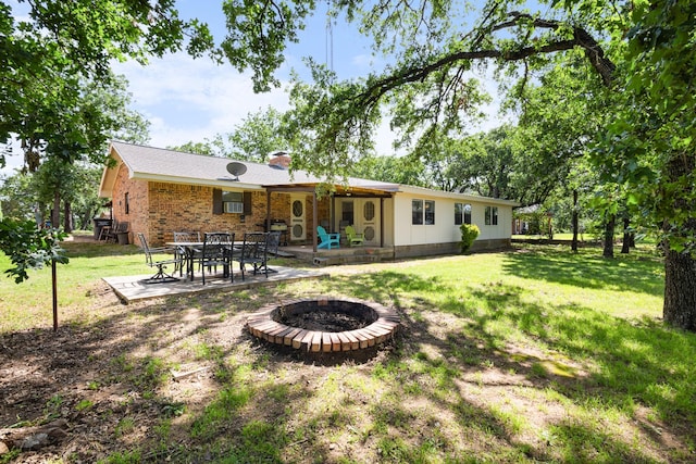 818 Country Club Rd, Bowie, TX 76230 - rear view of property with a fire pit, a patio, a lawn, and brick siding