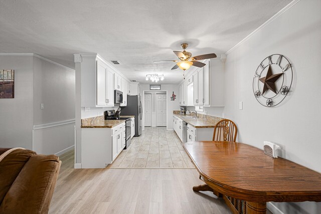818 Country Club Rd, Bowie, TX 76230 - kitchen with appliances with stainless steel finishes, a sink, ceiling fan, white cabinets, and light wood-type flooring