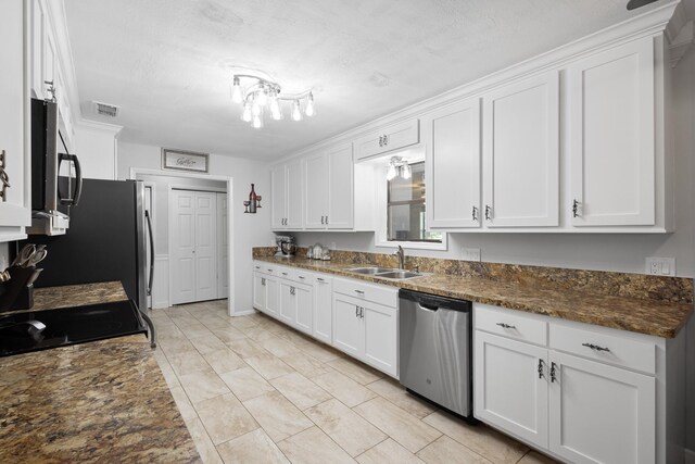 818 Country Club Rd, Bowie, TX 76230 - kitchen featuring stainless steel appliances, a sink, white cabinetry, light marble finish floors, and dark stone counters
