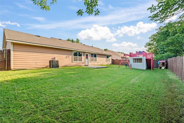 2813 Dana Ln, Denton, TX 76209 - back of house with central AC, a storage unit, and an outbuilding