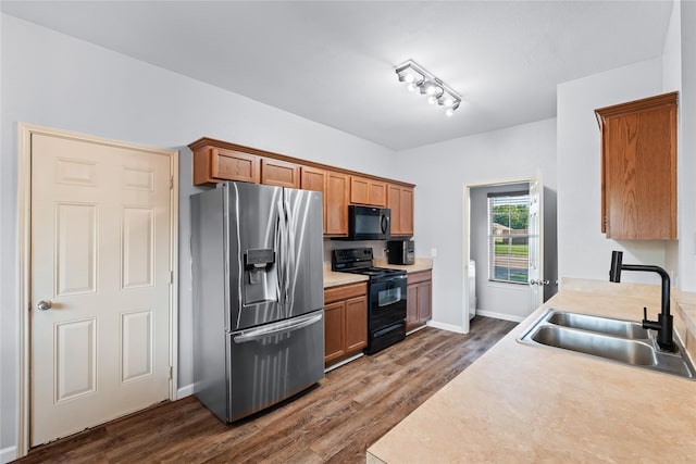 2813 Dana Ln, Denton, TX 76209 - kitchen featuring black appliances, a sink, dark wood-style flooring, light countertops, and brown cabinets