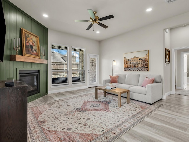 571 Mckenna Dr, Fate, TX 75087 - living area featuring a ceiling fan, wood finished floors, baseboards, a large fireplace, and recessed lighting
