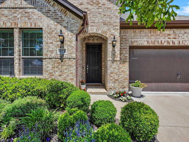 571 Mckenna Dr, Fate, TX 75087 - doorway to property with a garage, brick siding, and concrete driveway