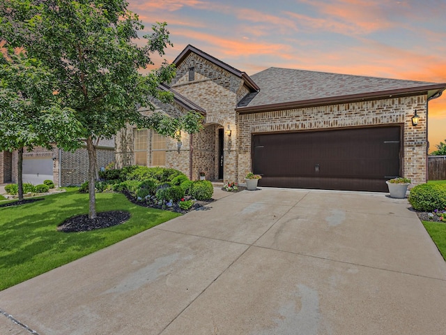 571 Mckenna Dr, Fate, TX 75087 - french country style house with brick siding, driveway, a front lawn, and a garage