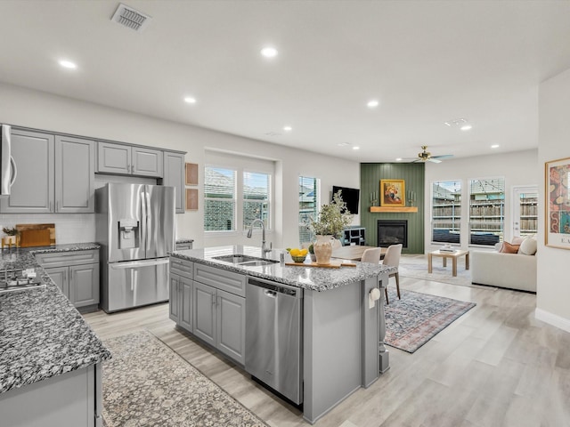 571 Mckenna Dr, Fate, TX 75087 - kitchen featuring gray cabinetry, a sink, stainless steel appliances, a fireplace, and recessed lighting