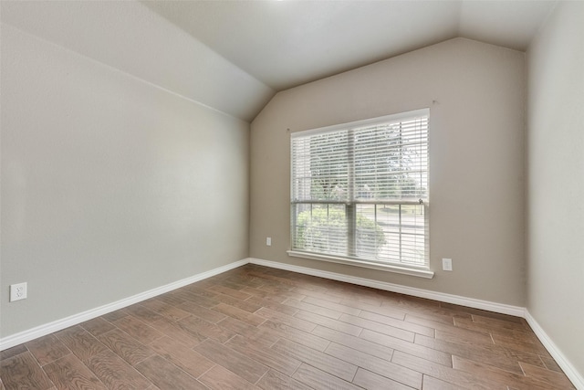 712 Britain Way, Wylie, TX 75098 - unfurnished room featuring lofted ceiling, wood finished floors, and baseboards