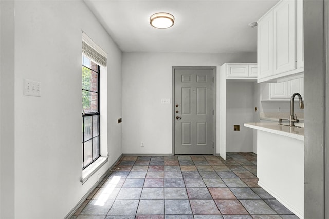 1407 W Mulberry St, Sherman, TX 75092 - kitchen featuring a sink, white cabinetry, light countertops, and light stone finish floors