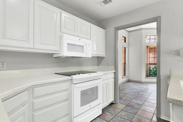 1407 W Mulberry St, Sherman, TX 75092 - kitchen with white appliances, light countertops, white cabinetry, light stone finish flooring, and baseboards