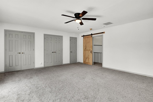 1407 W Mulberry St, Sherman, TX 75092 - unfurnished bedroom with carpet flooring, a barn door, multiple closets, baseboards, and a ceiling fan