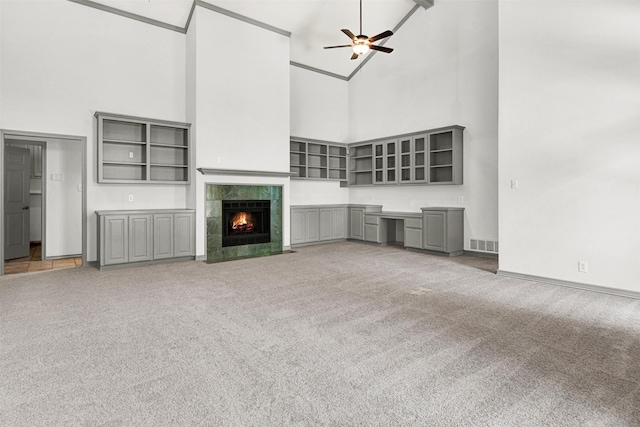 1407 W Mulberry St, Sherman, TX 75092 - unfurnished living room with a towering ceiling, carpet flooring, ceiling fan, baseboards, and a tiled fireplace